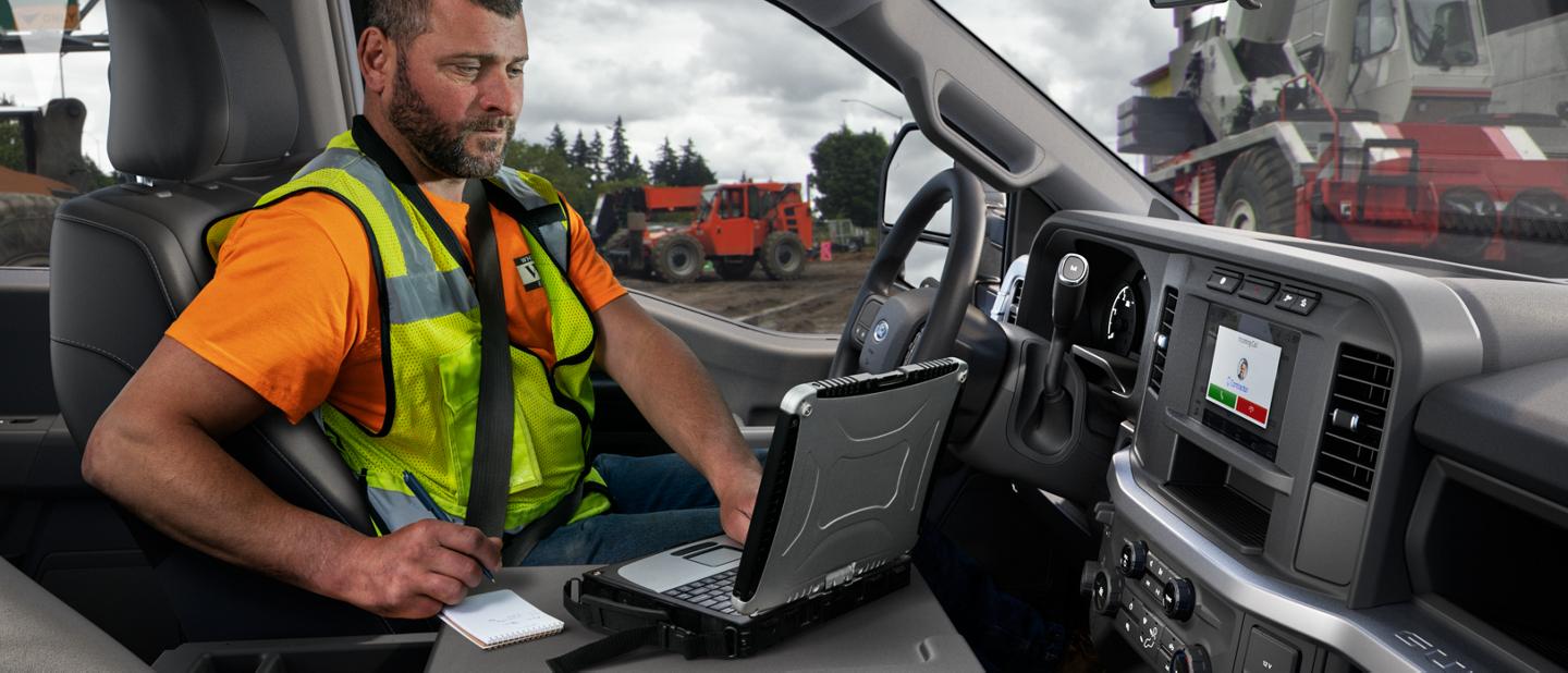 Man working on a laptop computer inside a 2025 Ford Super Duty® pickup