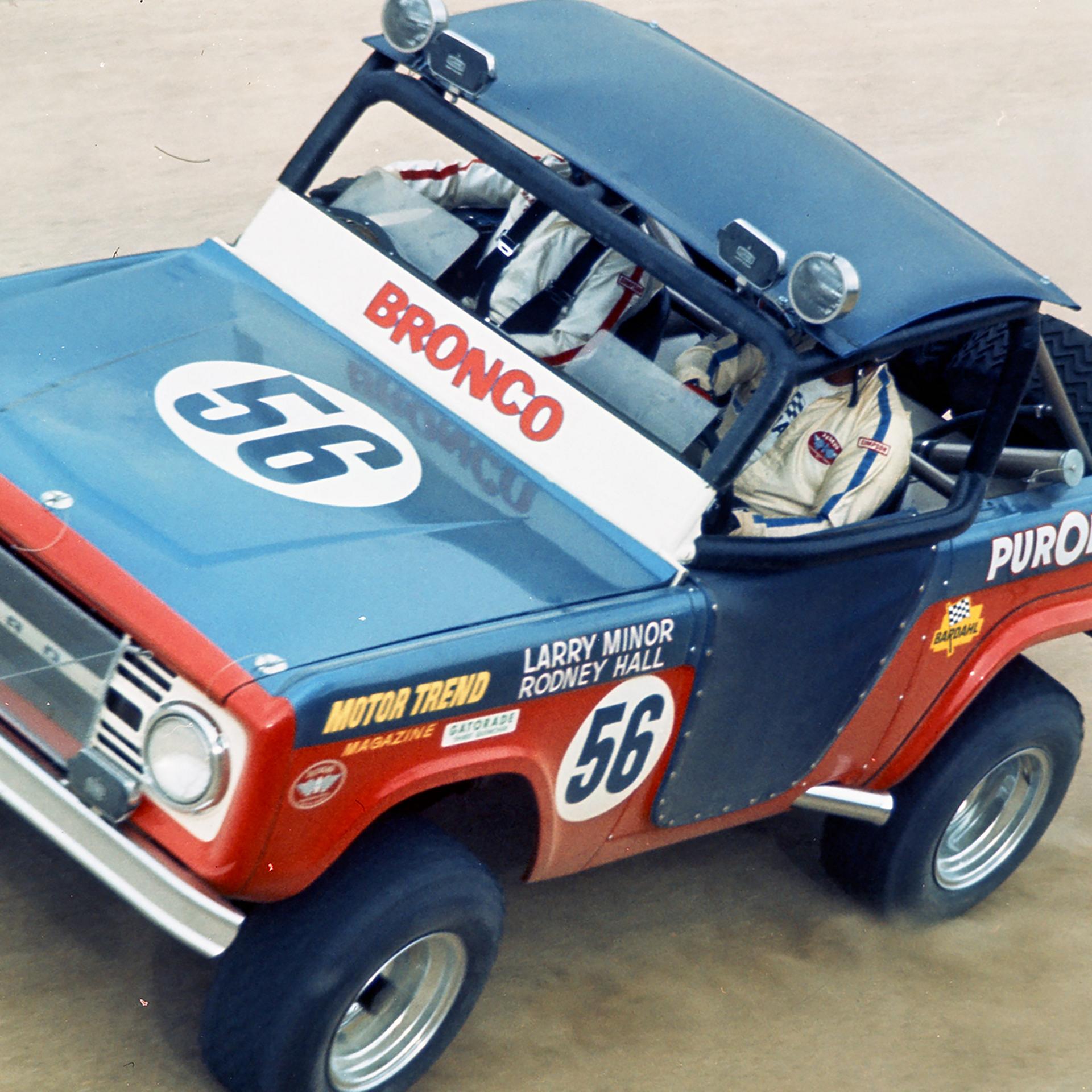 A 1968 Ford Bronco® racing model being driven on a dusty track