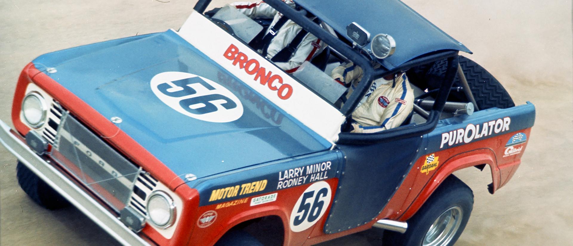 A 1968 Ford Bronco® racing model being driven on a dusty track