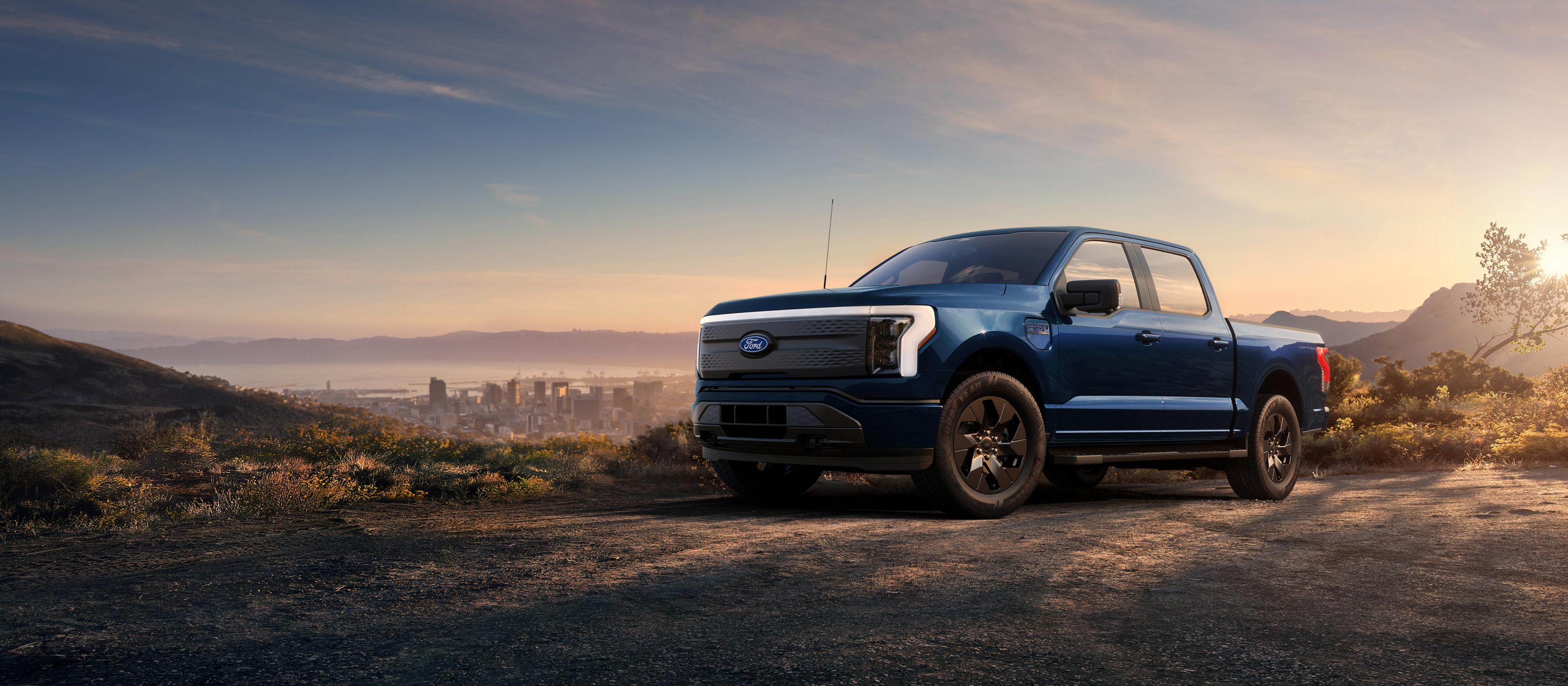 Ford F-150® Lightning® parked next to a field at dusk
