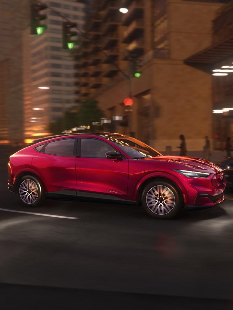 Red Ford Mustang Mach-E driving through city