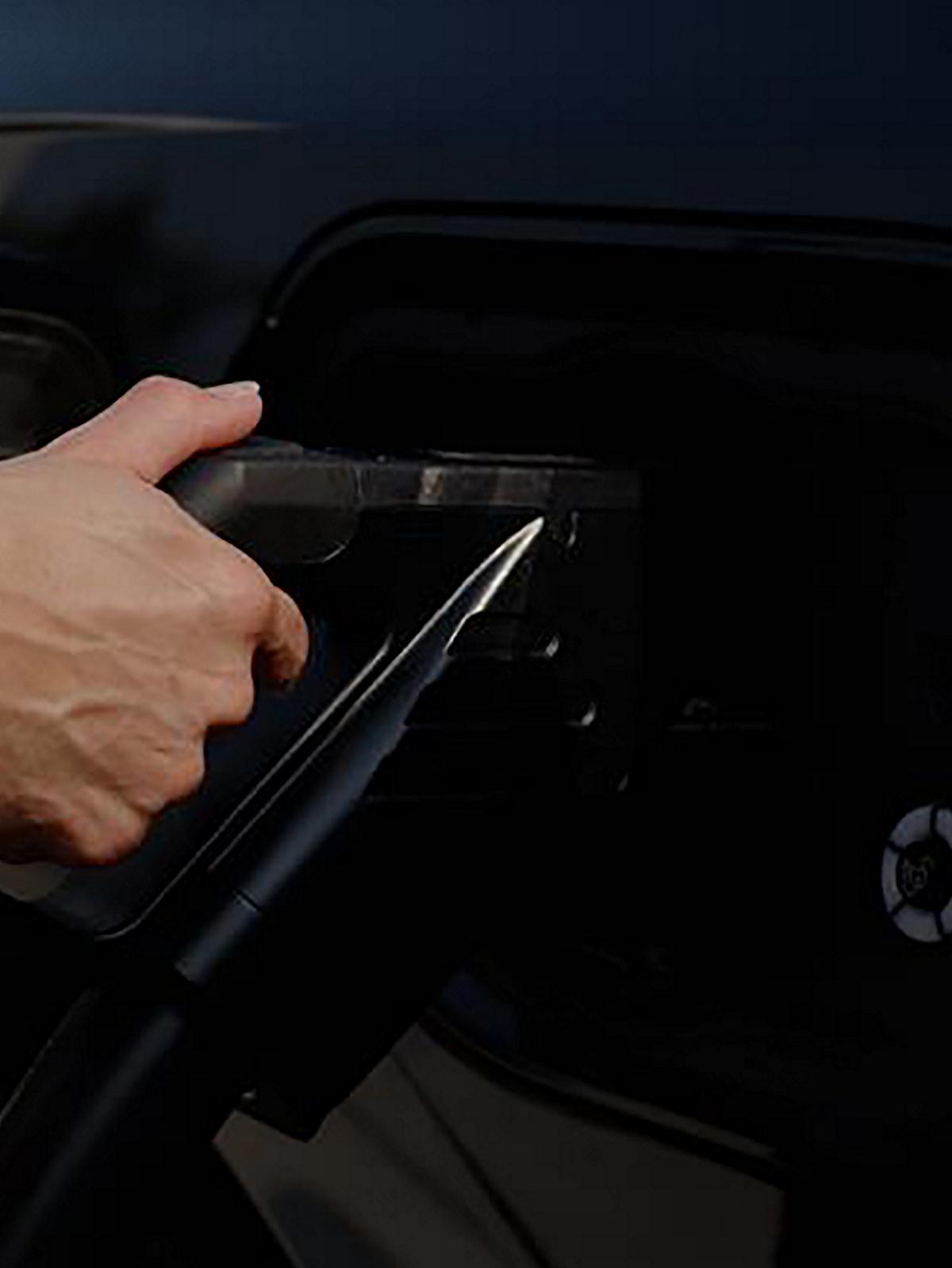 Plugging a charger into a black Ford F-150 Lightning truck