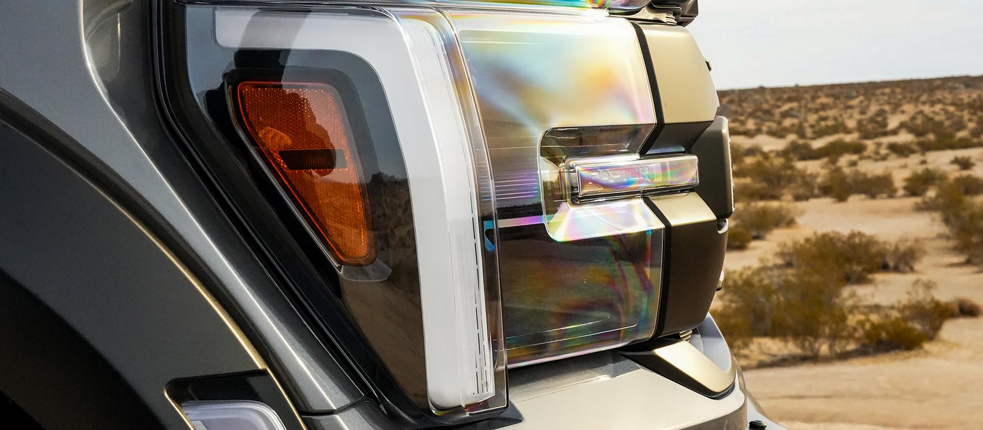 Close-up of the headlamp and side marker light of a 2026 Ford F-150® truck parked in the desert