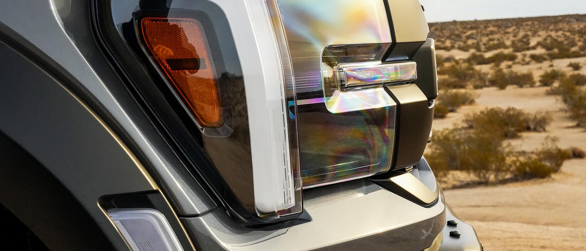 Close-up of the headlamp and side marker light of a 2026 Ford F-150® truck parked in the desert