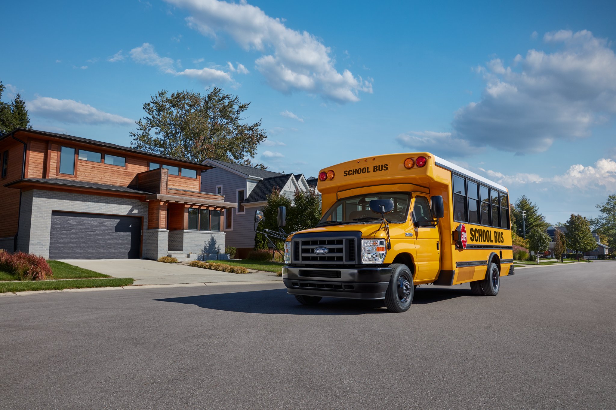 Fourgon tronqué à roues arrière jumelées Ford série E 2025 avec aménagement d’autobus scolaire dans une banlieue