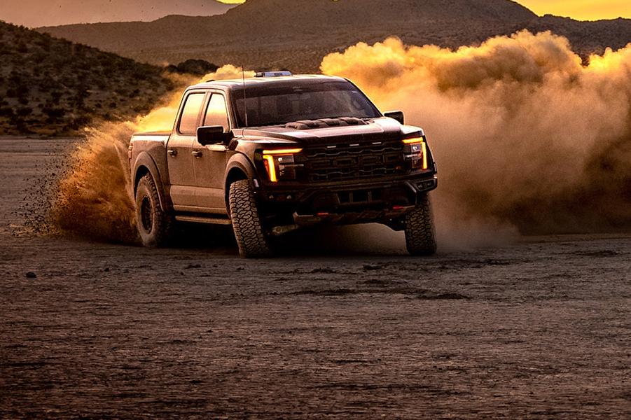 A 2024 Ford F-150® Raptor® kicks up dust as it powers through a desert course at sunset