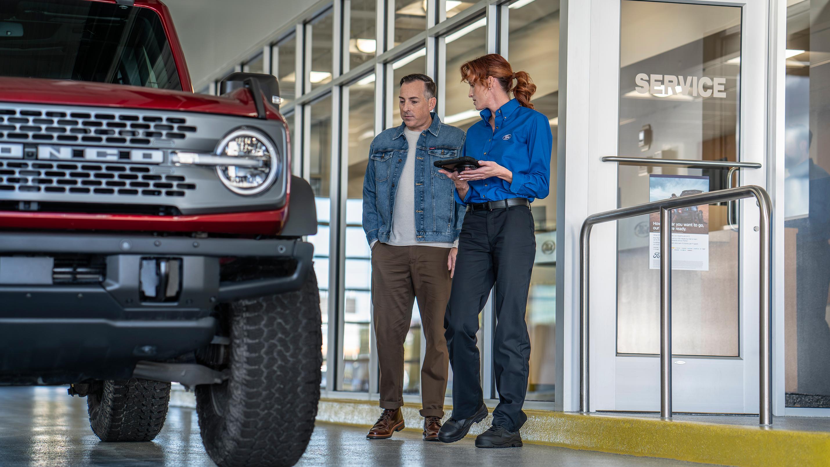 A Ford Service representative walks a customer through their maintenance needs