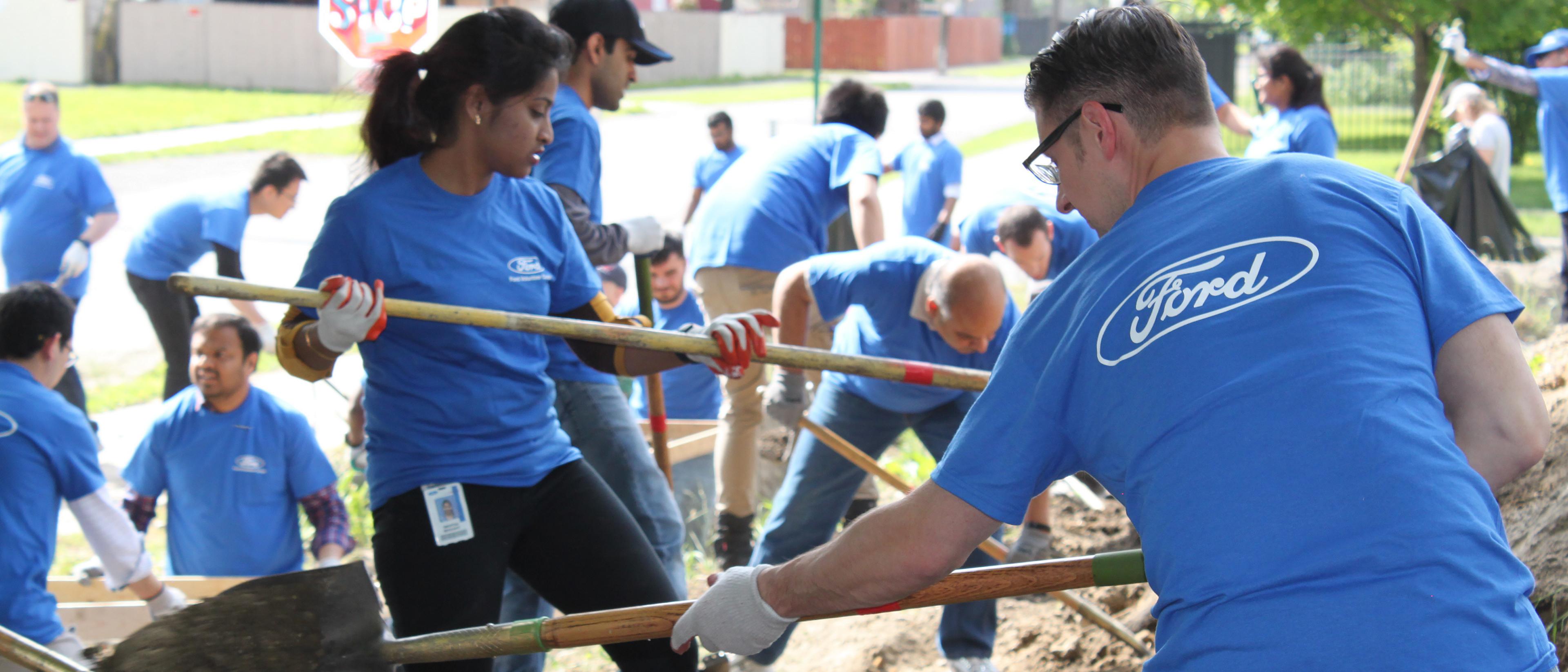 Ford volunteers work on a cleanup and beautification crew in a neighborhood