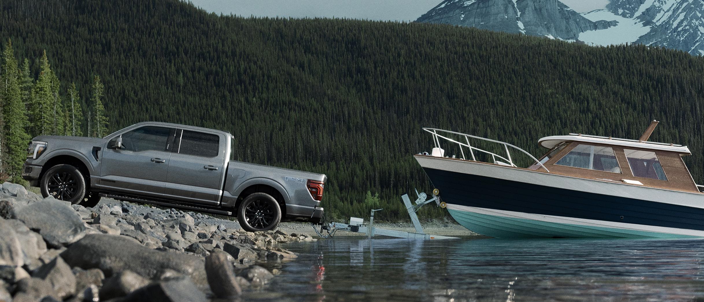 2026 Ford F-150® Lariat® with FX4® Off-Road Package backing a boat into the water at a boat launch