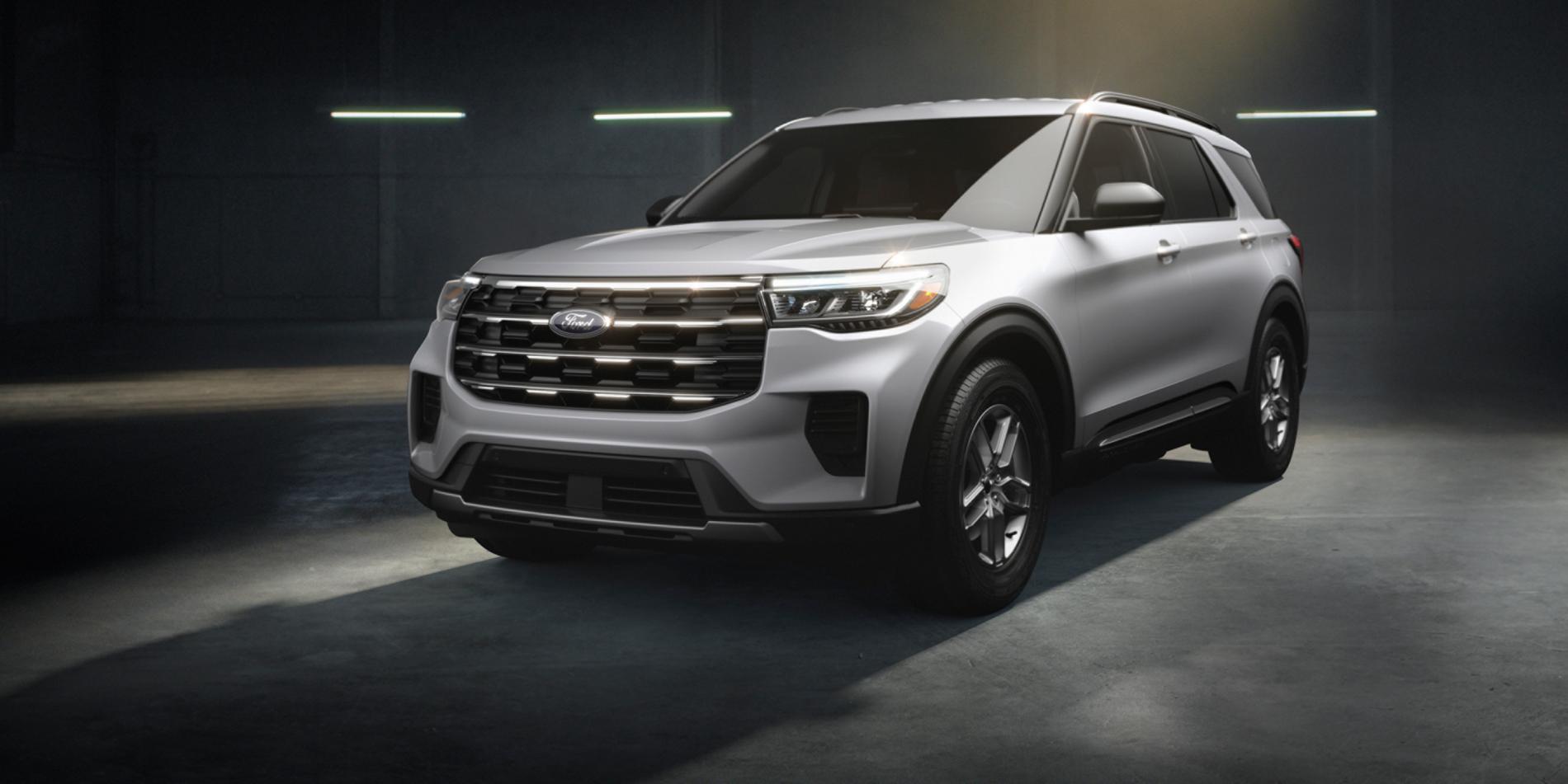 A white 2025 Ford Explorer SUV sitting in a warehouse environment with dramatic lighting