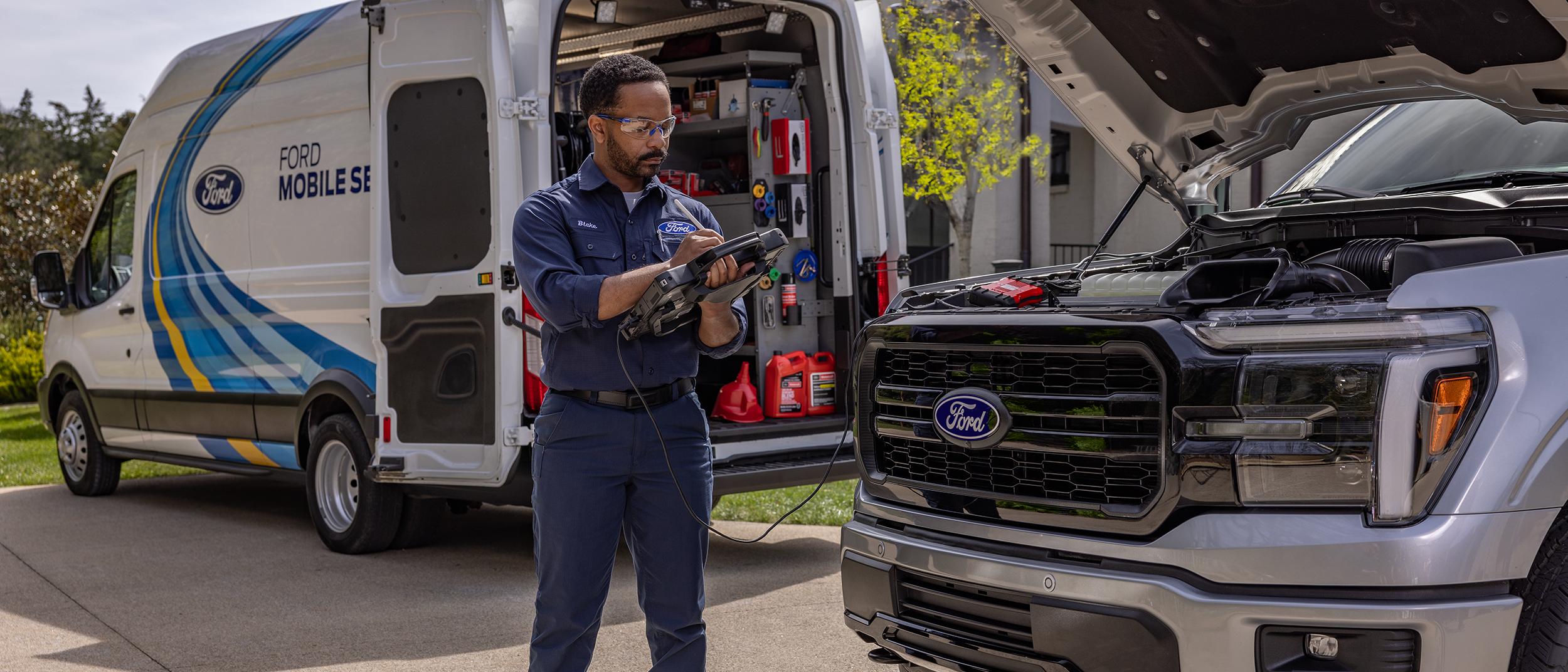 A Ford Mobile Service tech performs a maintenance test on a Ford F-150® truck in a customer’s driveway