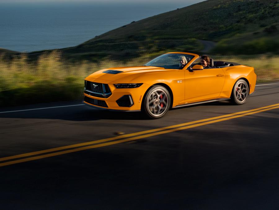 A 2026 Ford Mustang® GT Premium Convertible model being driven on a seaside highway
