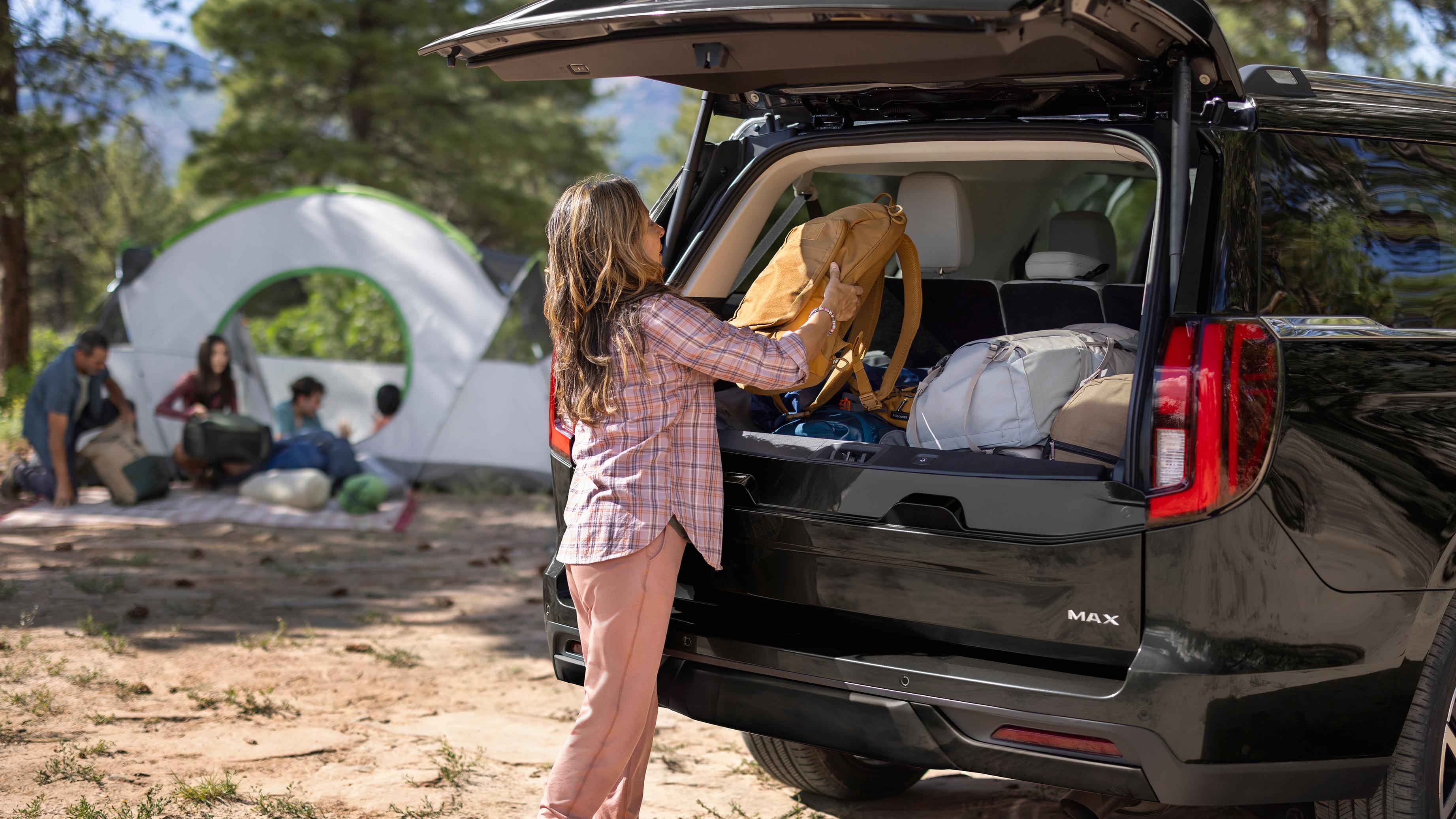Person loading camping gear with the Ford Split Gate open in a 2027 Ford Expedition® SUV