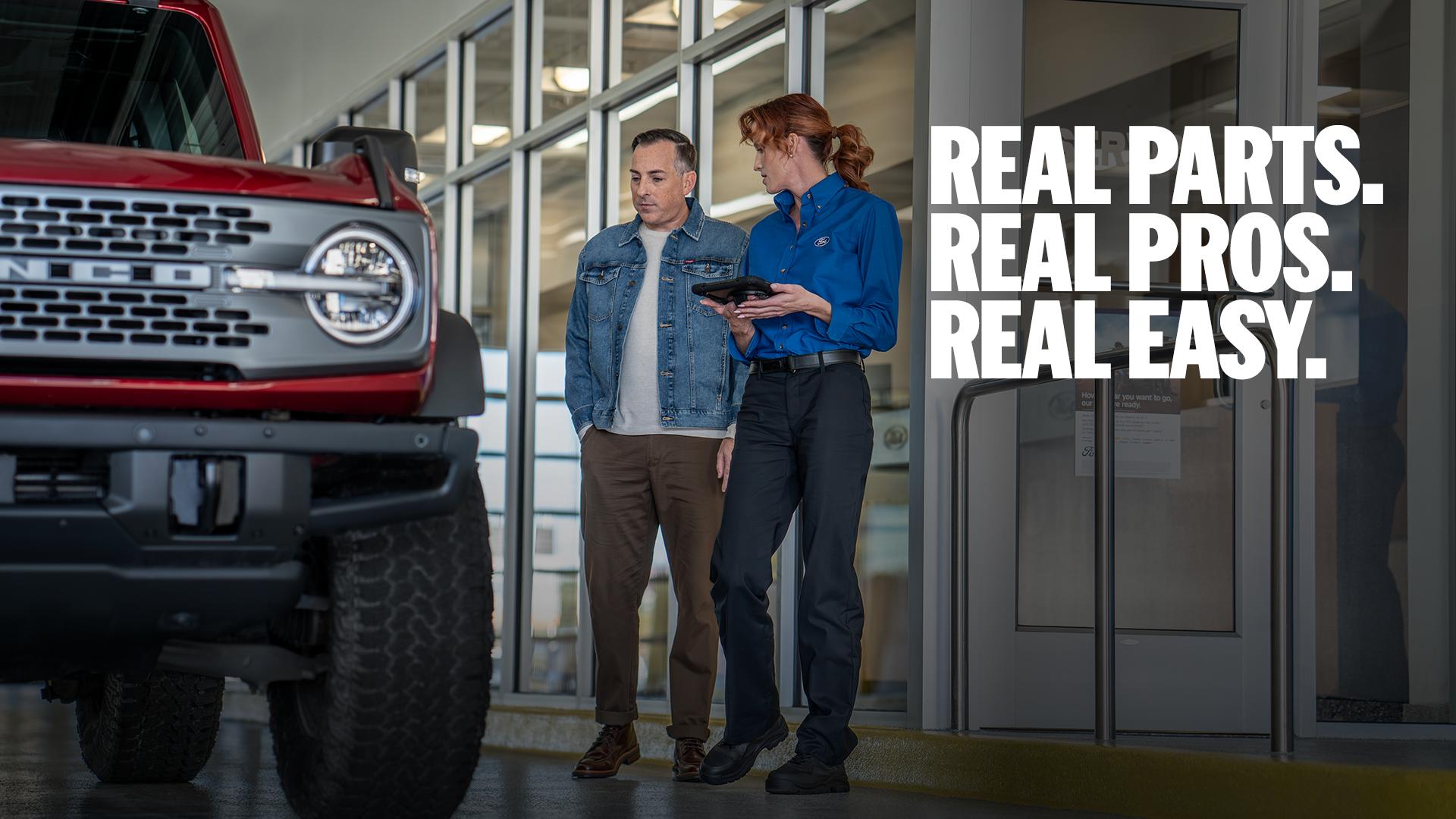 A Ford Service representative walks a customer through their maintenance needs