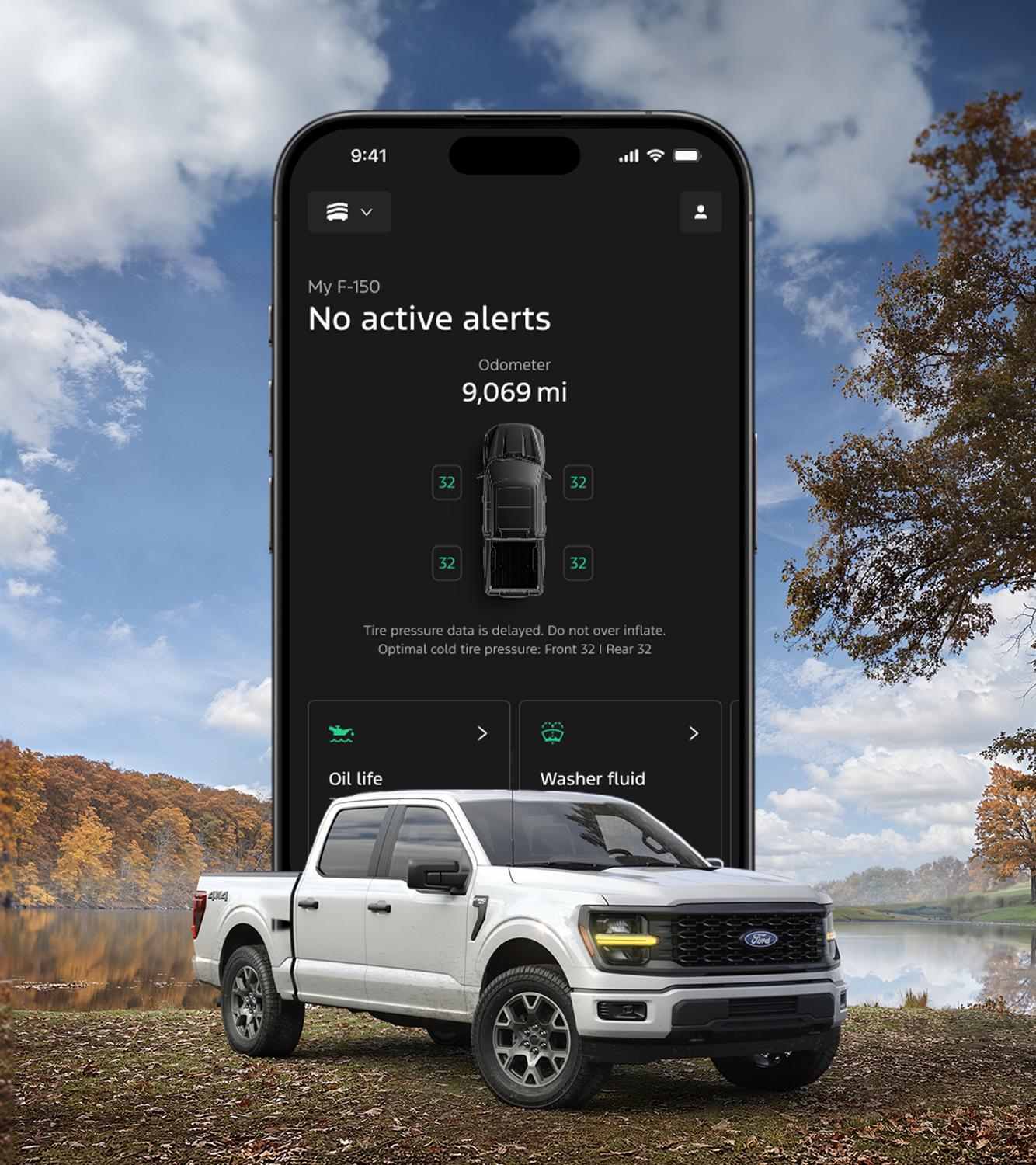The Ford app screen displays on the horizon behind a 2026 Ford F-150® truck parked lakeside