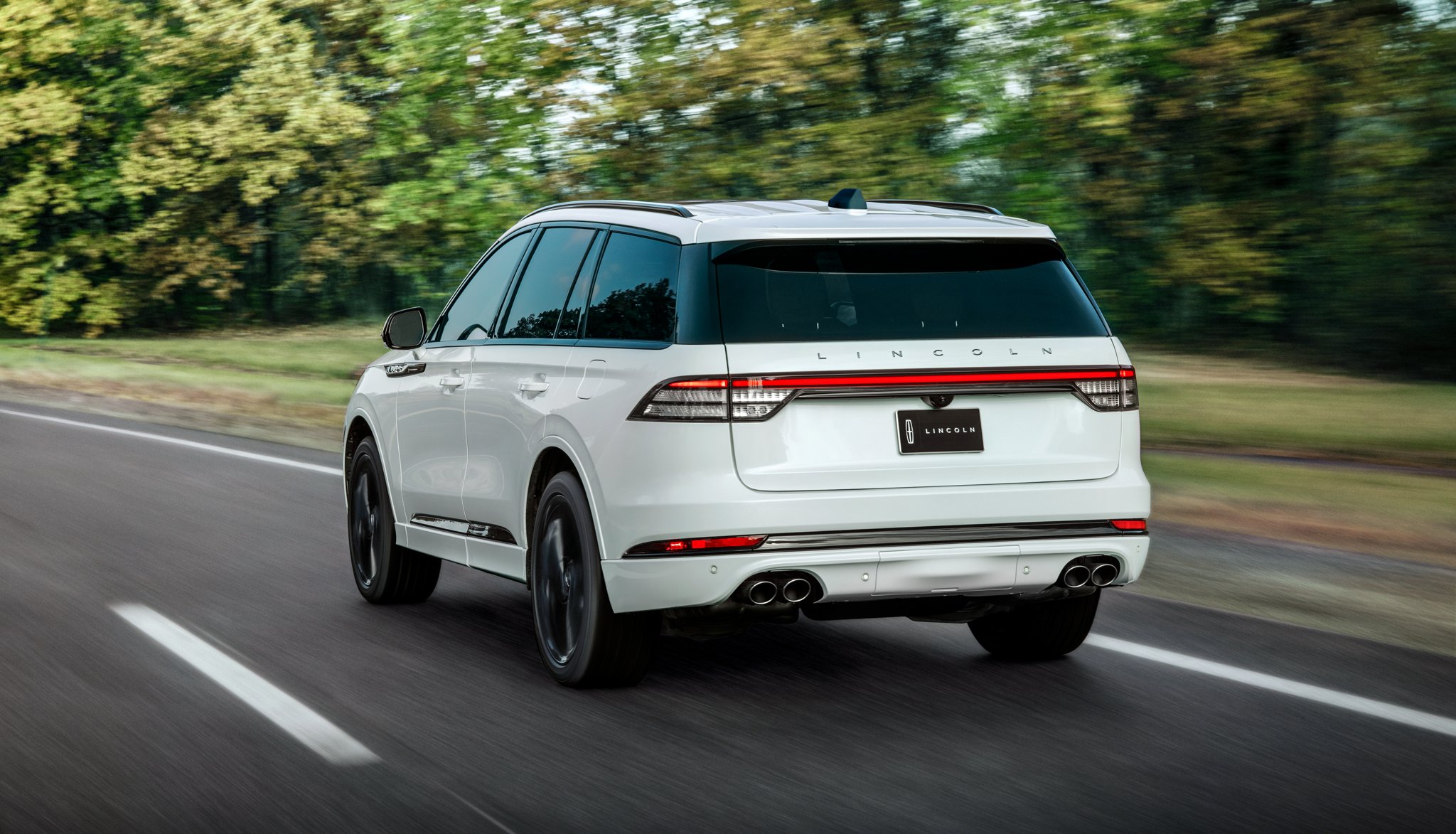 Un Lincoln Aviator 2025 conduit sur une route forestière