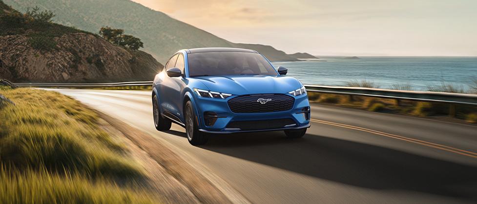 2025 Ford Mustang Mach-E driving down coastal highway