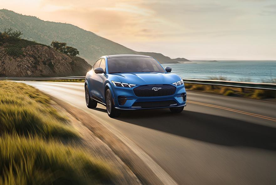 2025 Ford Mustang Mach-E driving down coastal highway