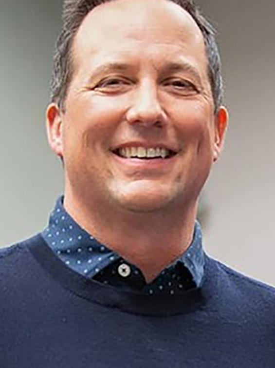 Two employees smile at camera