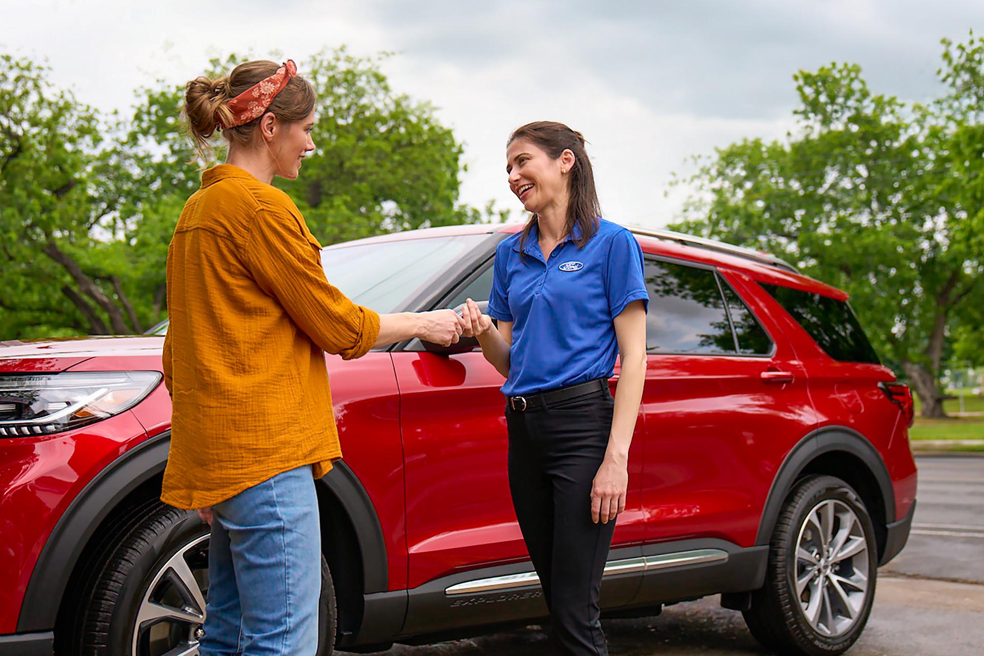 A Ford Mobile technician returns a Ford Explorer® owner's keys back to them