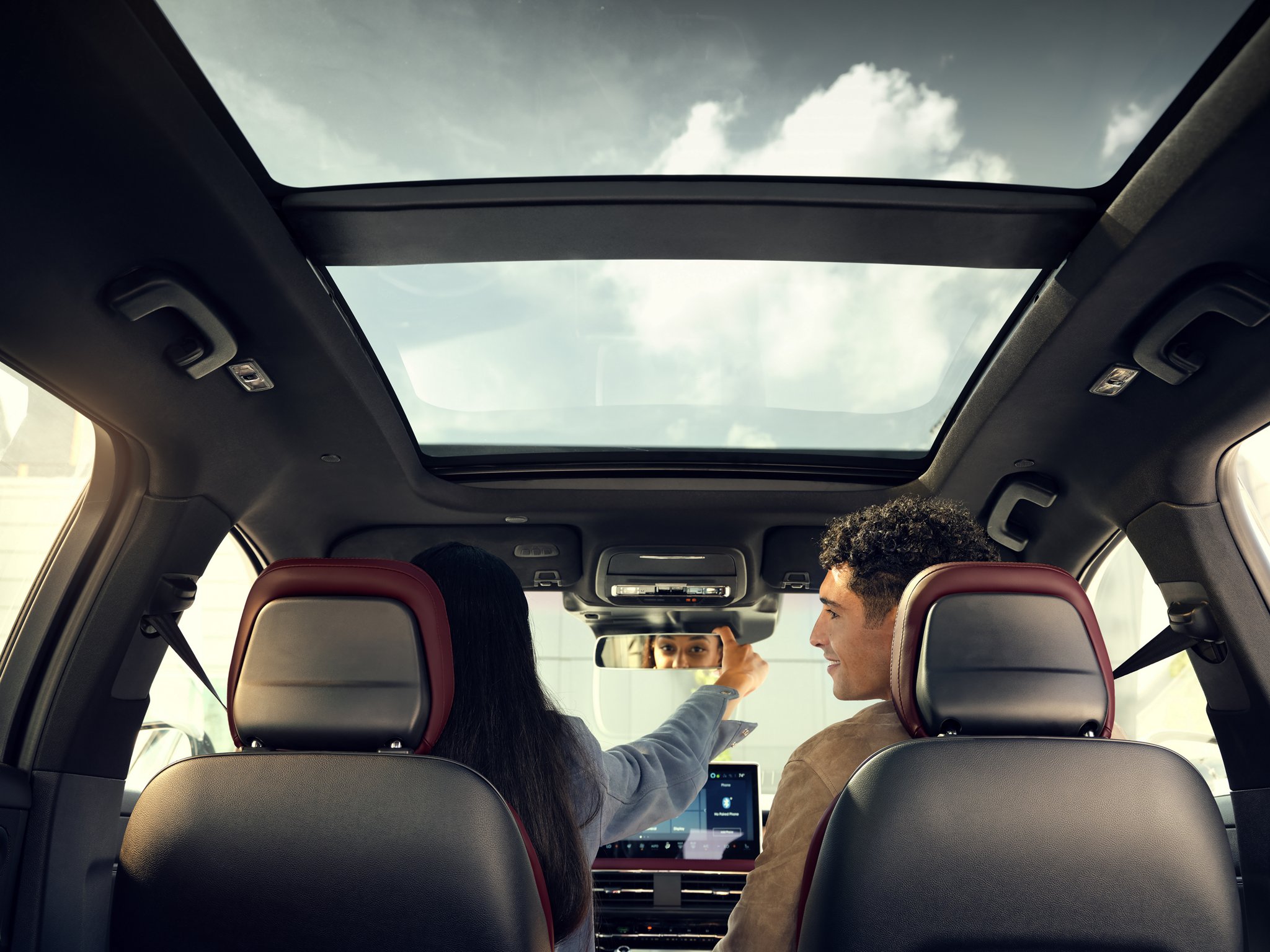 The driver of a 2025 Lincoln Corsair adjusts the frameless rearview mirror