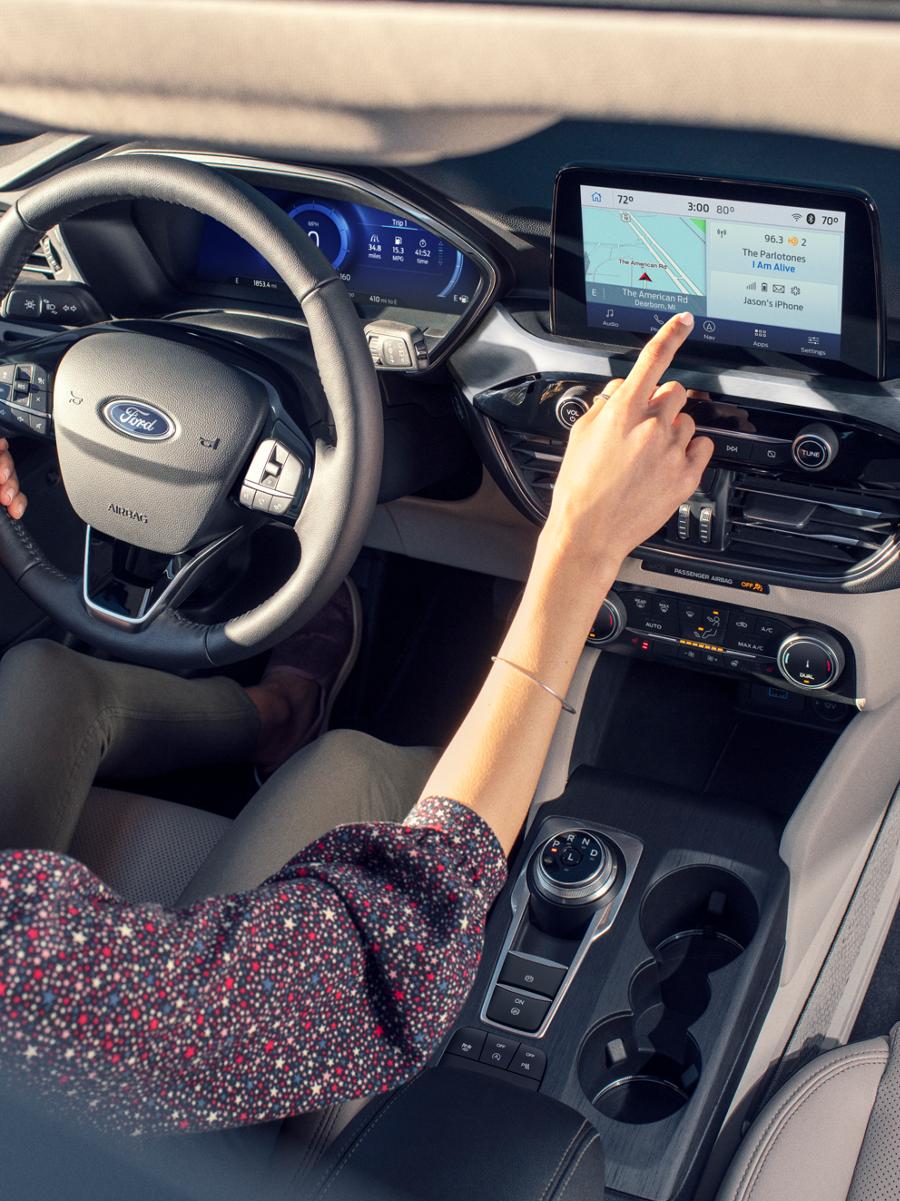 Une femme conduisant un véhicule Ford.