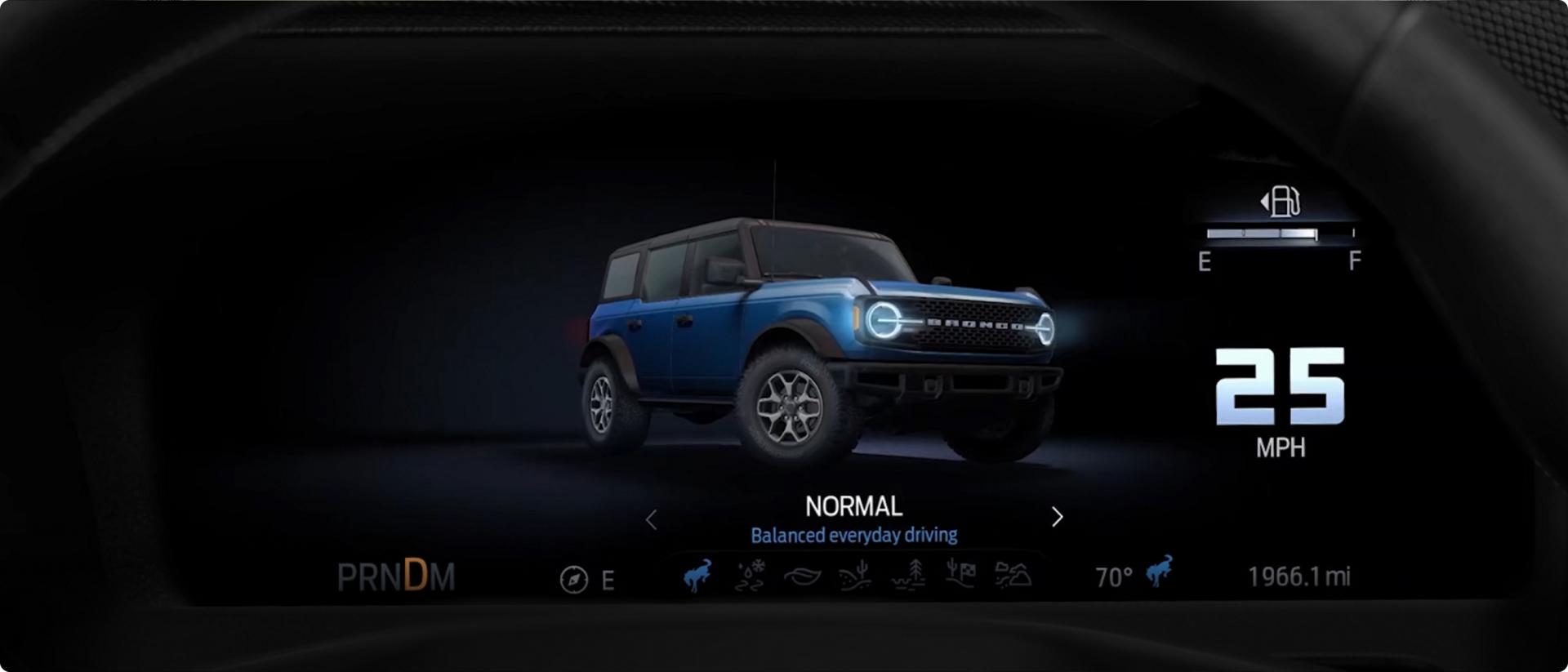 A driver's seat view of a digital dashboard displaying an animation of G.O.A.T. (Goes Over Any Type of Terrain) Mode