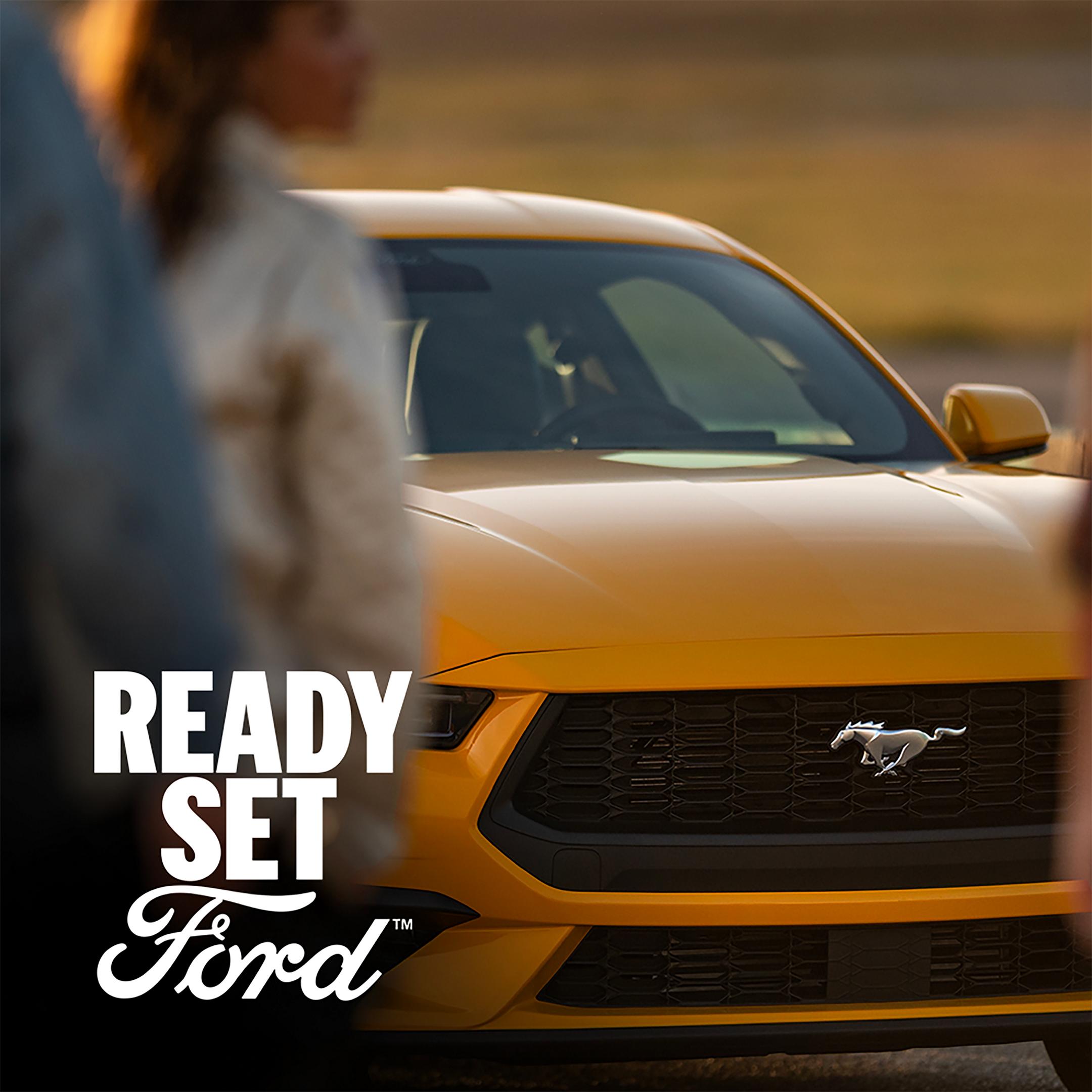 Yellow 2026 Ford Mustang® GR Premium Coupe parked with a woman in the foreground