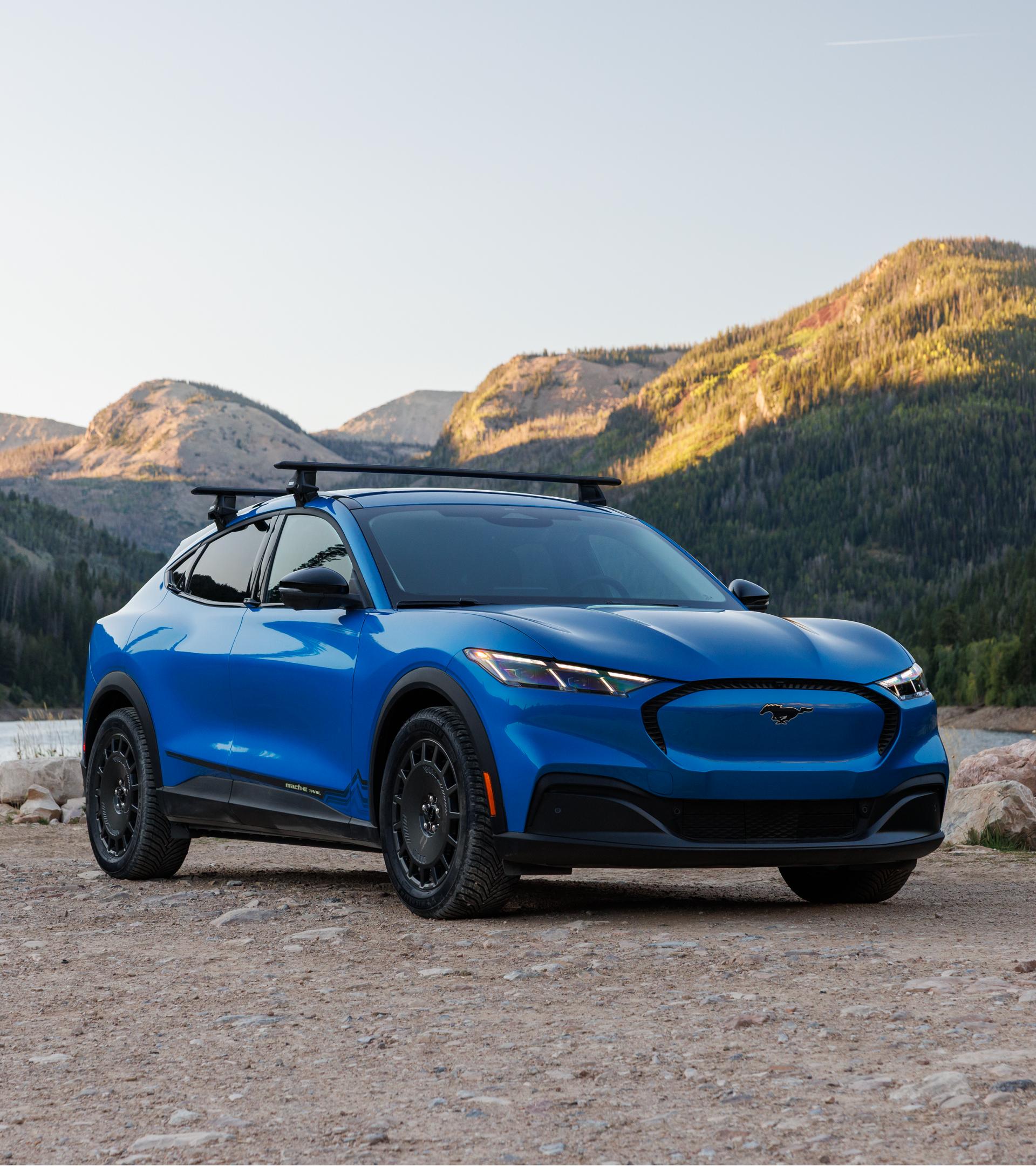 2027 Ford Mustang Mach-E® SUV with optional Trail package and available Ford bike rack accessory parked off road