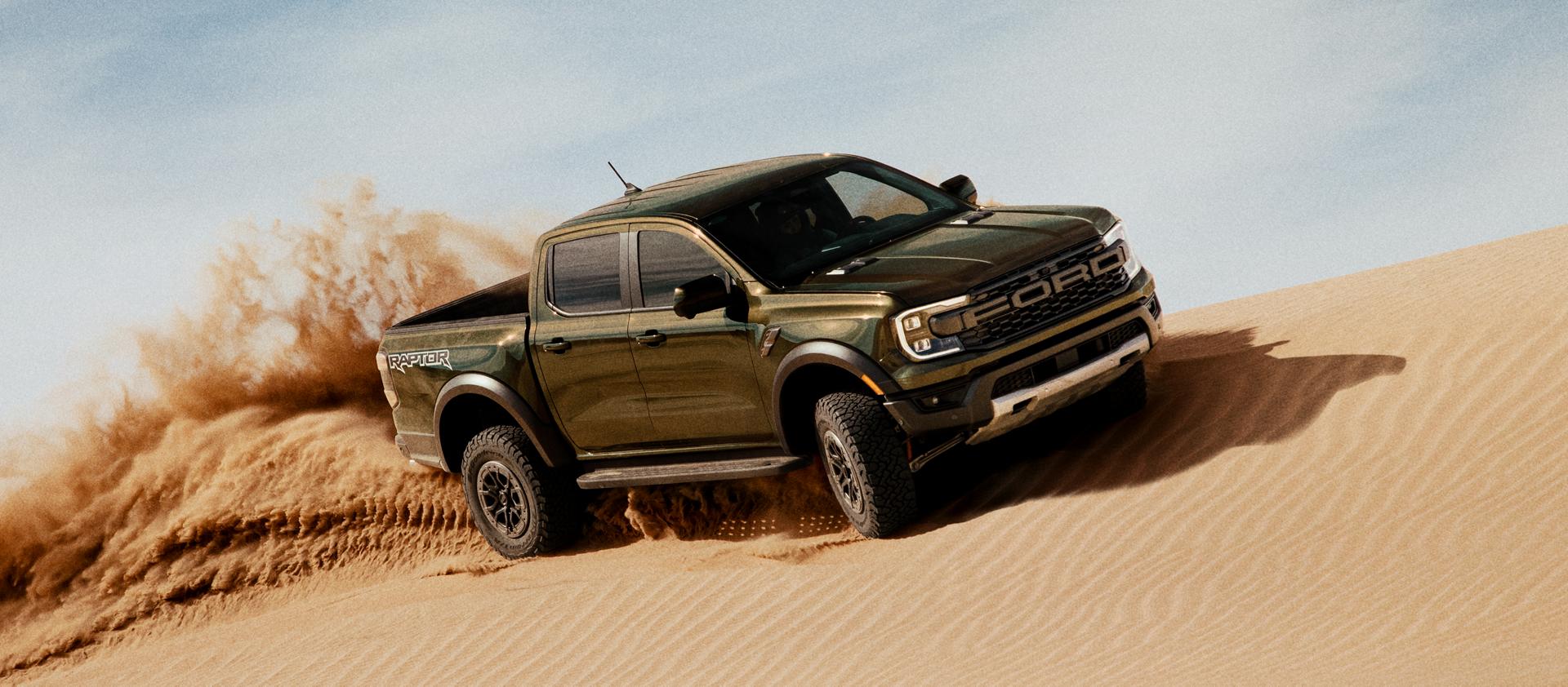 2026 Ford Ranger Raptor® truck kicking up sand while being driven on a sand dune