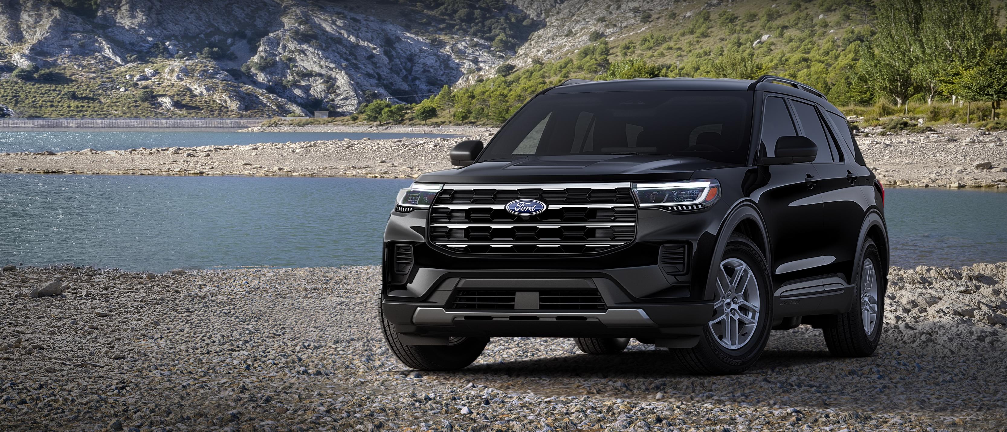 A 2026 Ford Explorer® Active model parked on a rocky expanse near a mountain lake