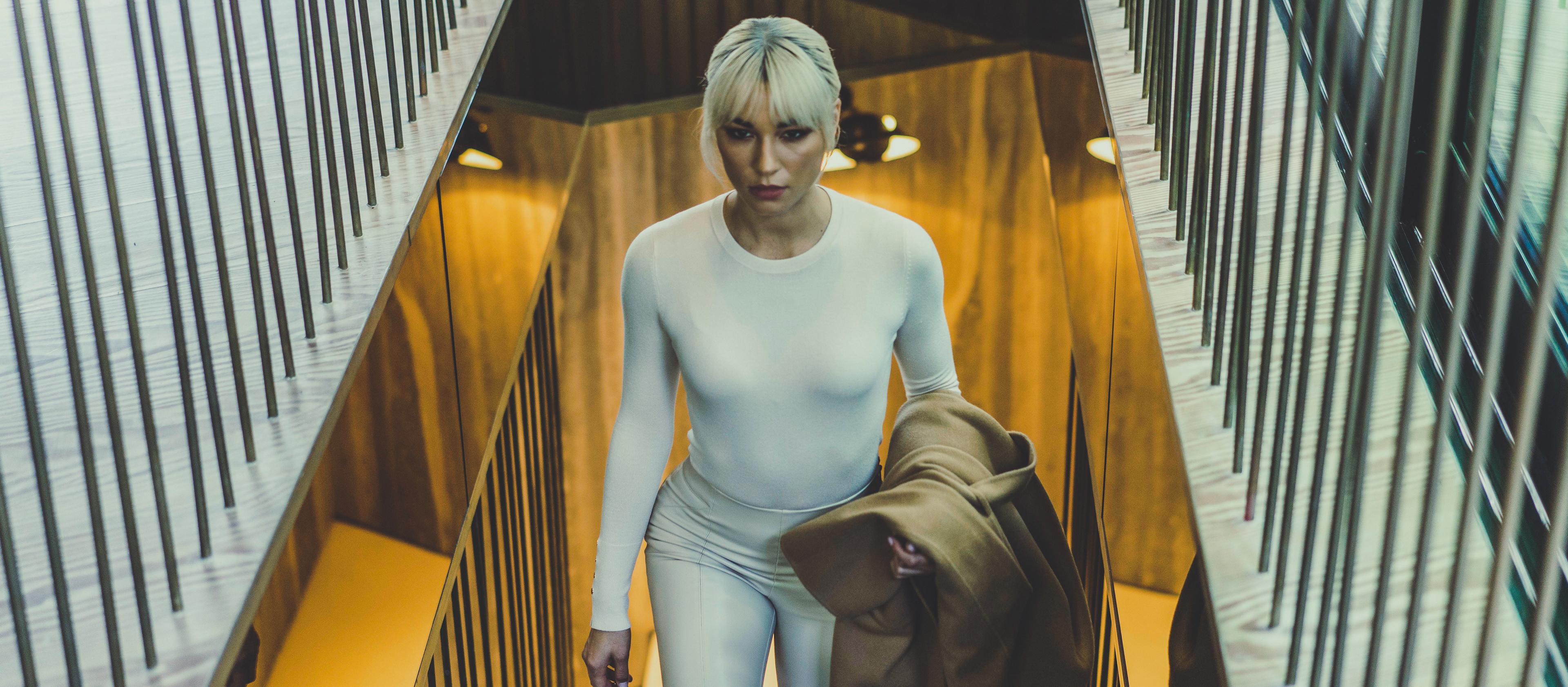 A woman ascends a stairway in a mountain chalet