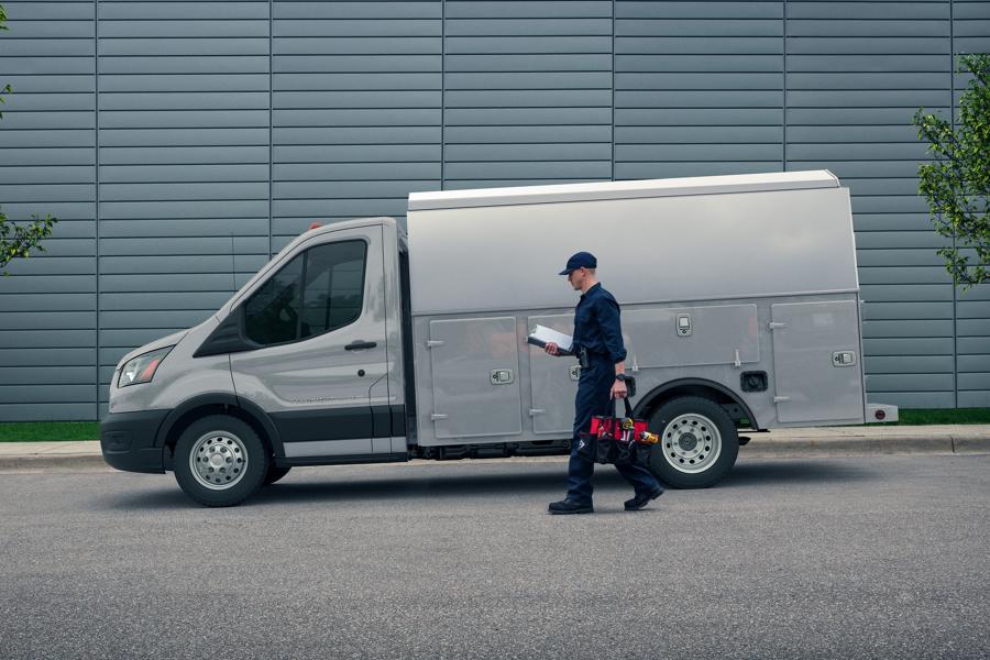 A person approaching a 2025 Ford Transit® Chassis Cab model with mechanic's truck upfit