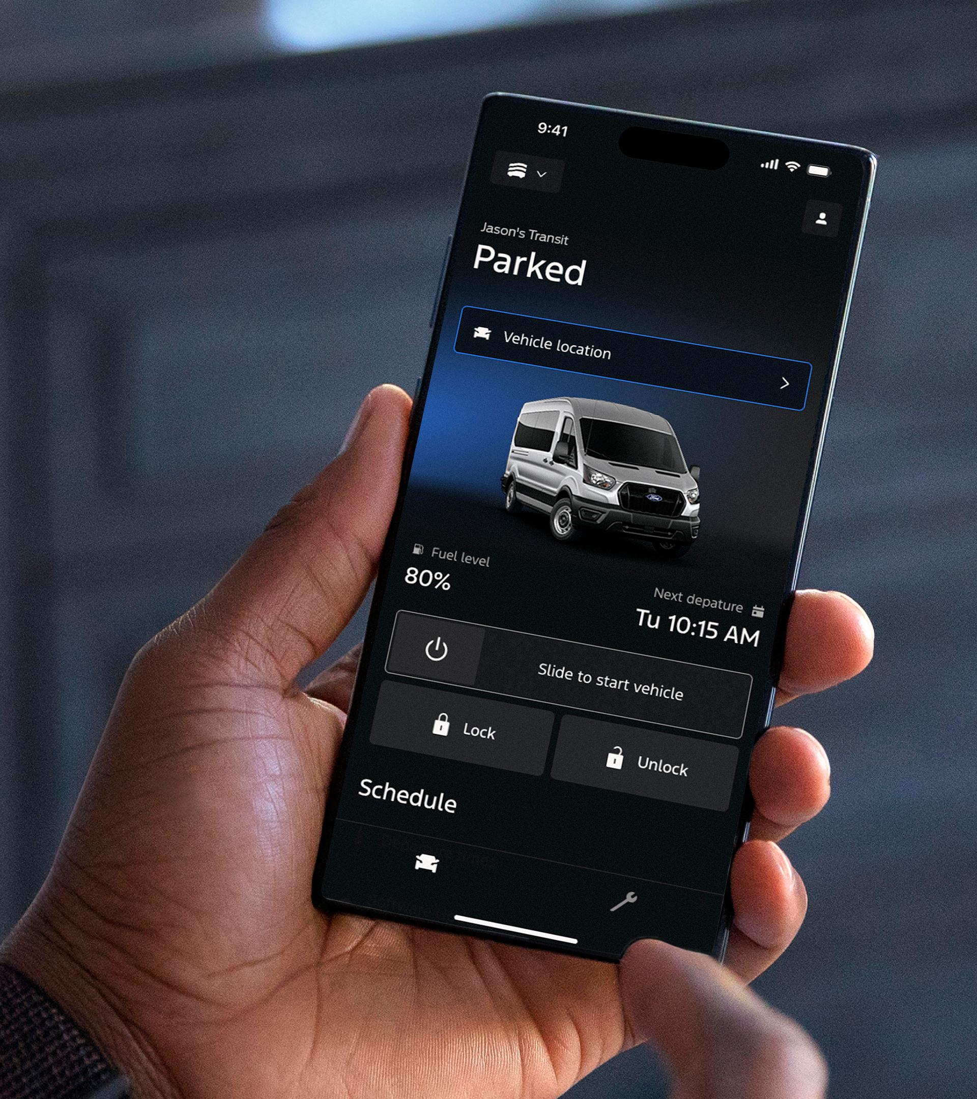 Main tenant un téléphone mobile avec l’écran d’accueil de l’application Ford en vue