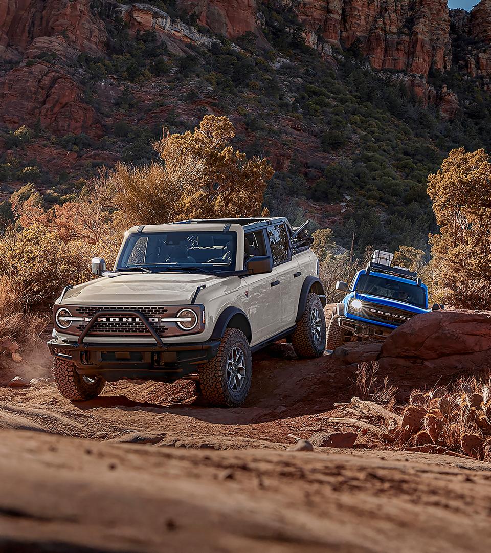A line of 2026 Ford Bronco® SUVs parked next to each other on a mud flat