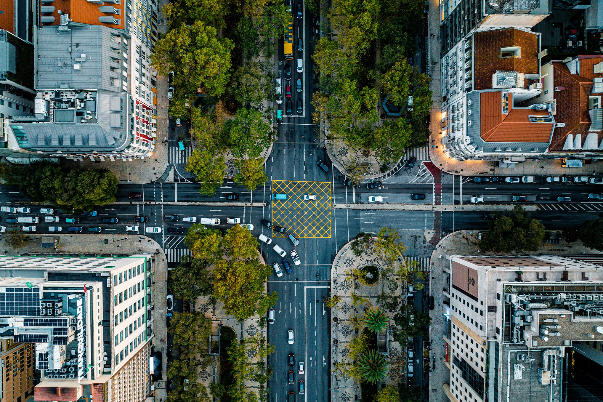 A busy city street with many cars travelling on the road.