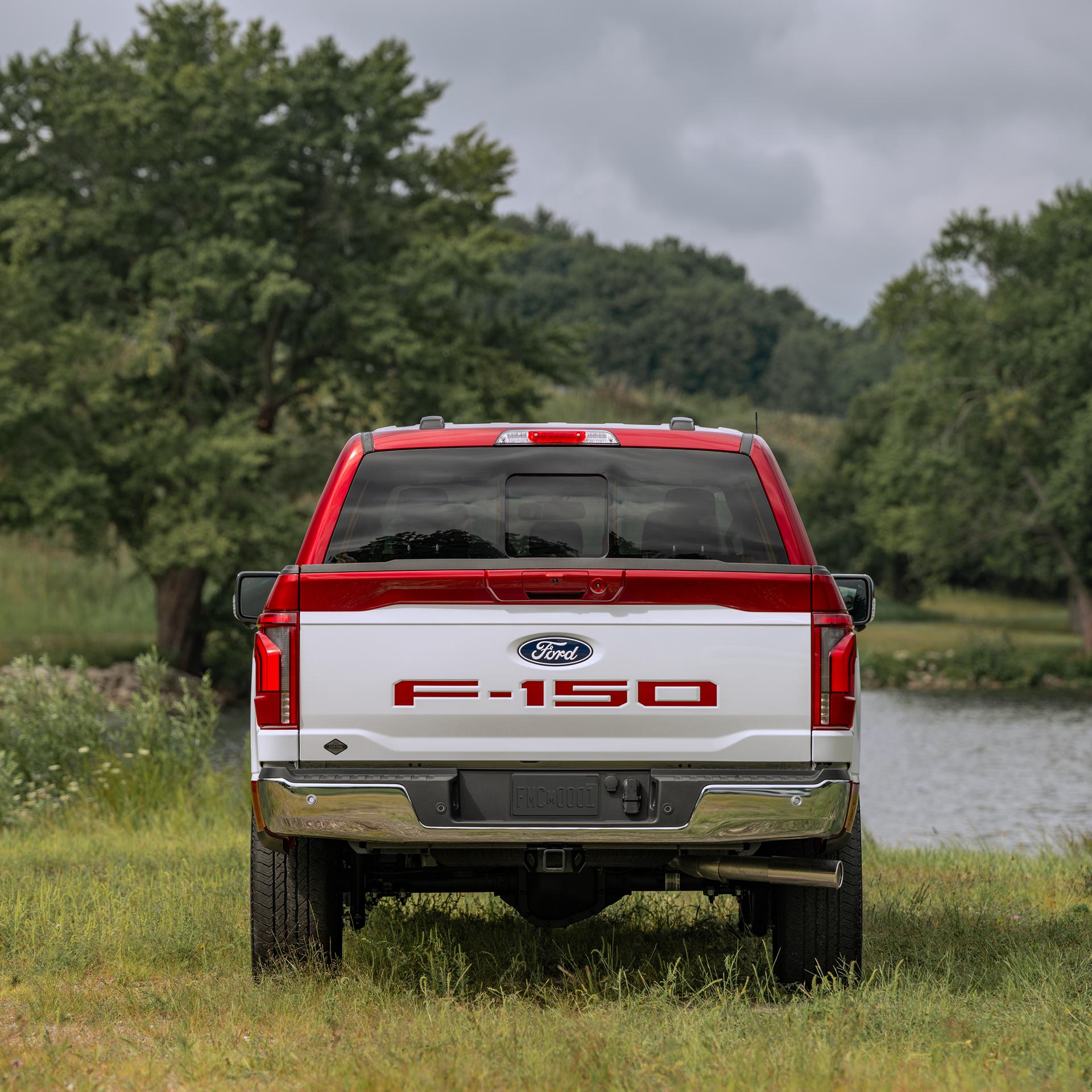 Rear view of a 2027 Ford F-150® Two-Tone Package with white and red two-tone exterior near a lake