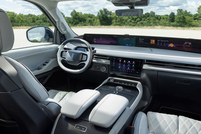 Una toma de conducción interior de la Lincoln Navigator® 2026 que muestra al conductor usando el Asistente de Google activado por voz