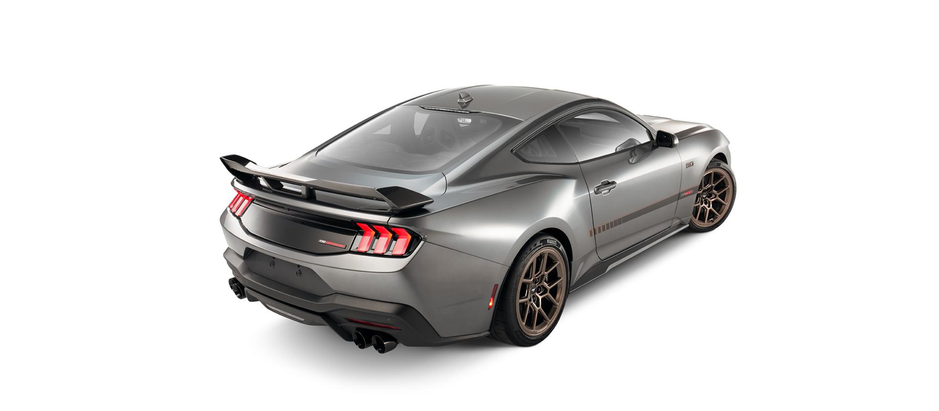 Rear three-quarter view of the gray Mustang with the rear spoiler and bronze wheels