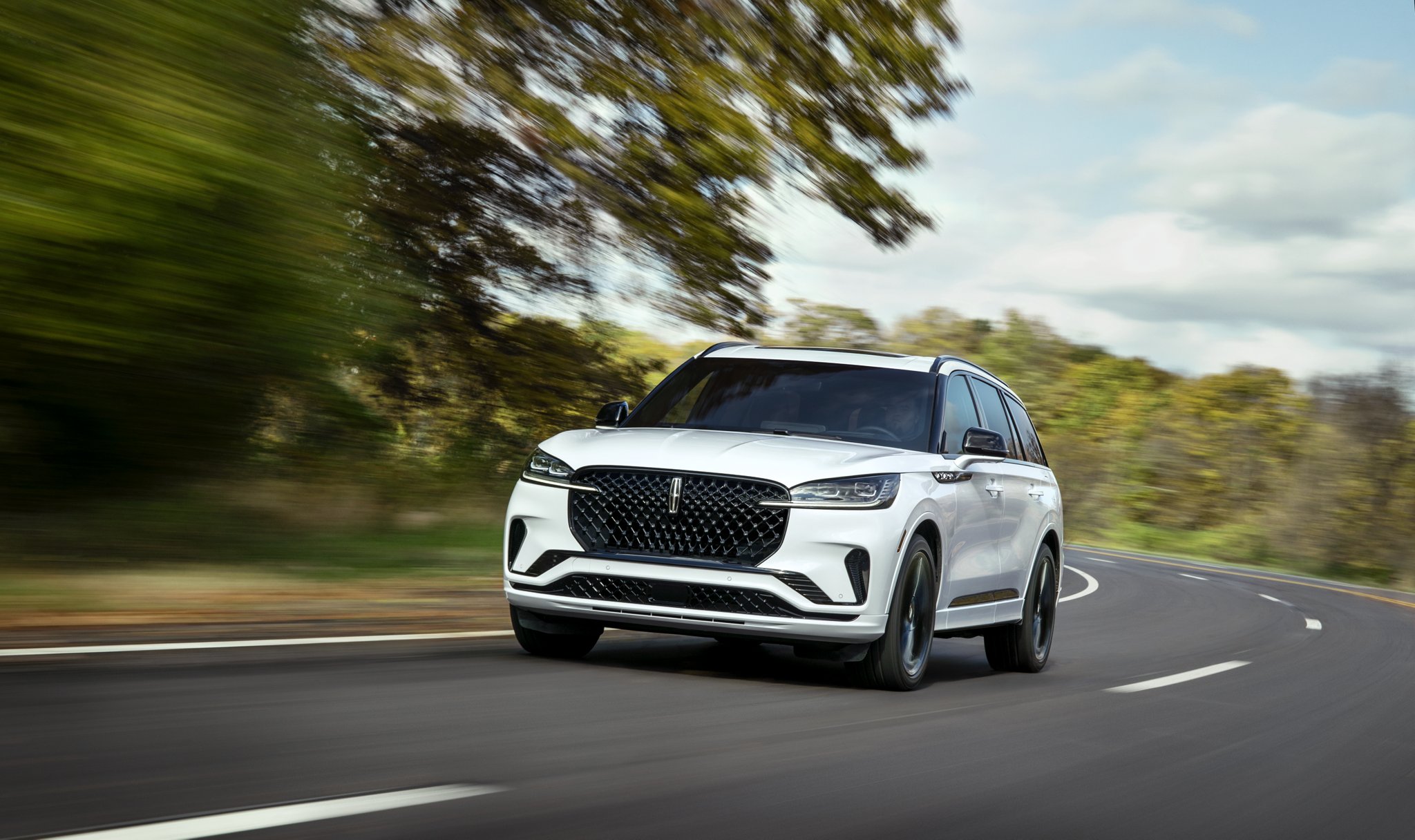 Un Lincoln Aviator 2025 conduit sur une route forestière
