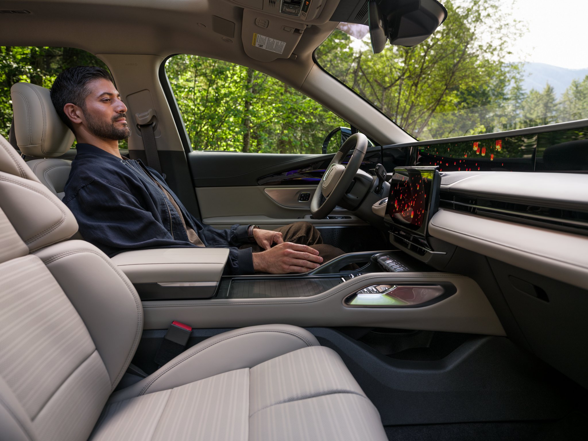A person enjoys Lincoln Embrace while seated in the driver's seat of a parked 2026 Lincoln Nautilus