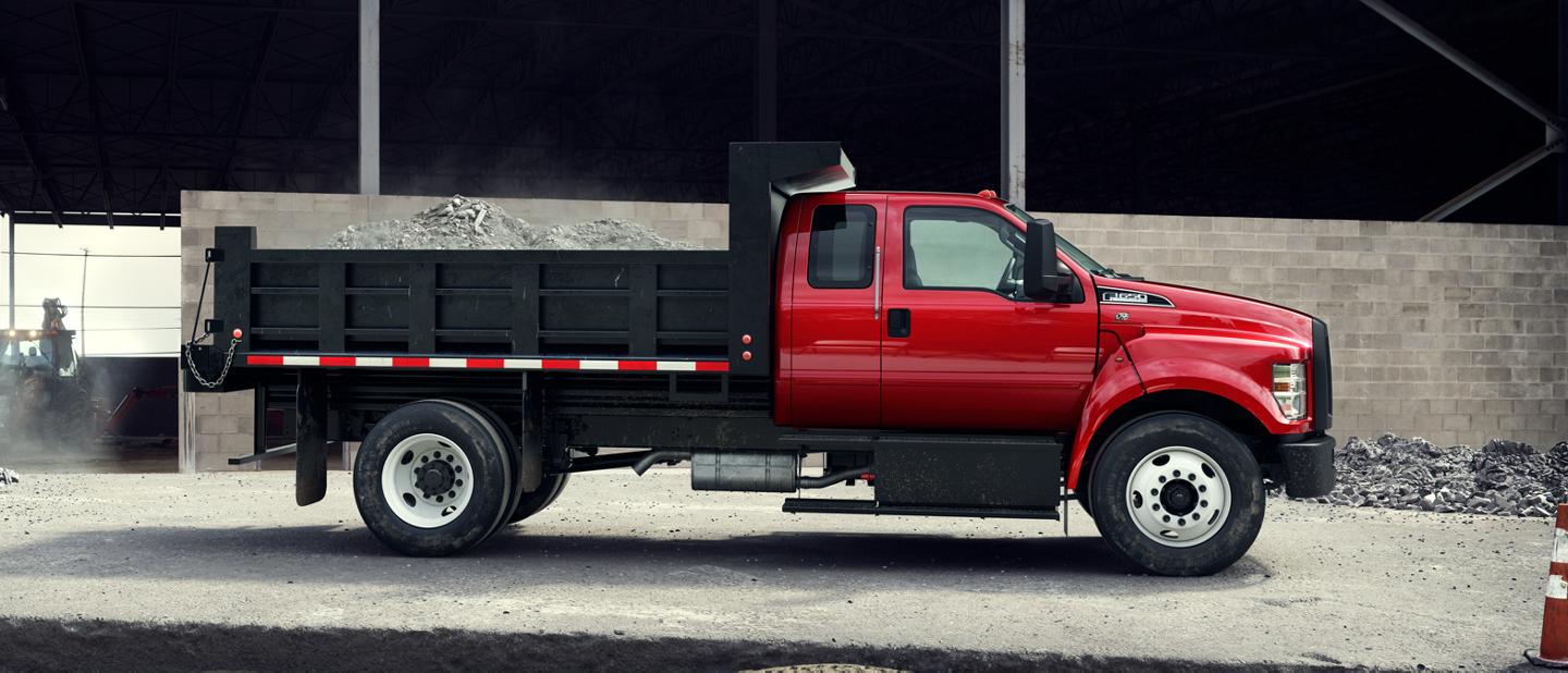 Ford F-650 2025 à cabine double illustré en rouge course avec un aménagement de camion à benne