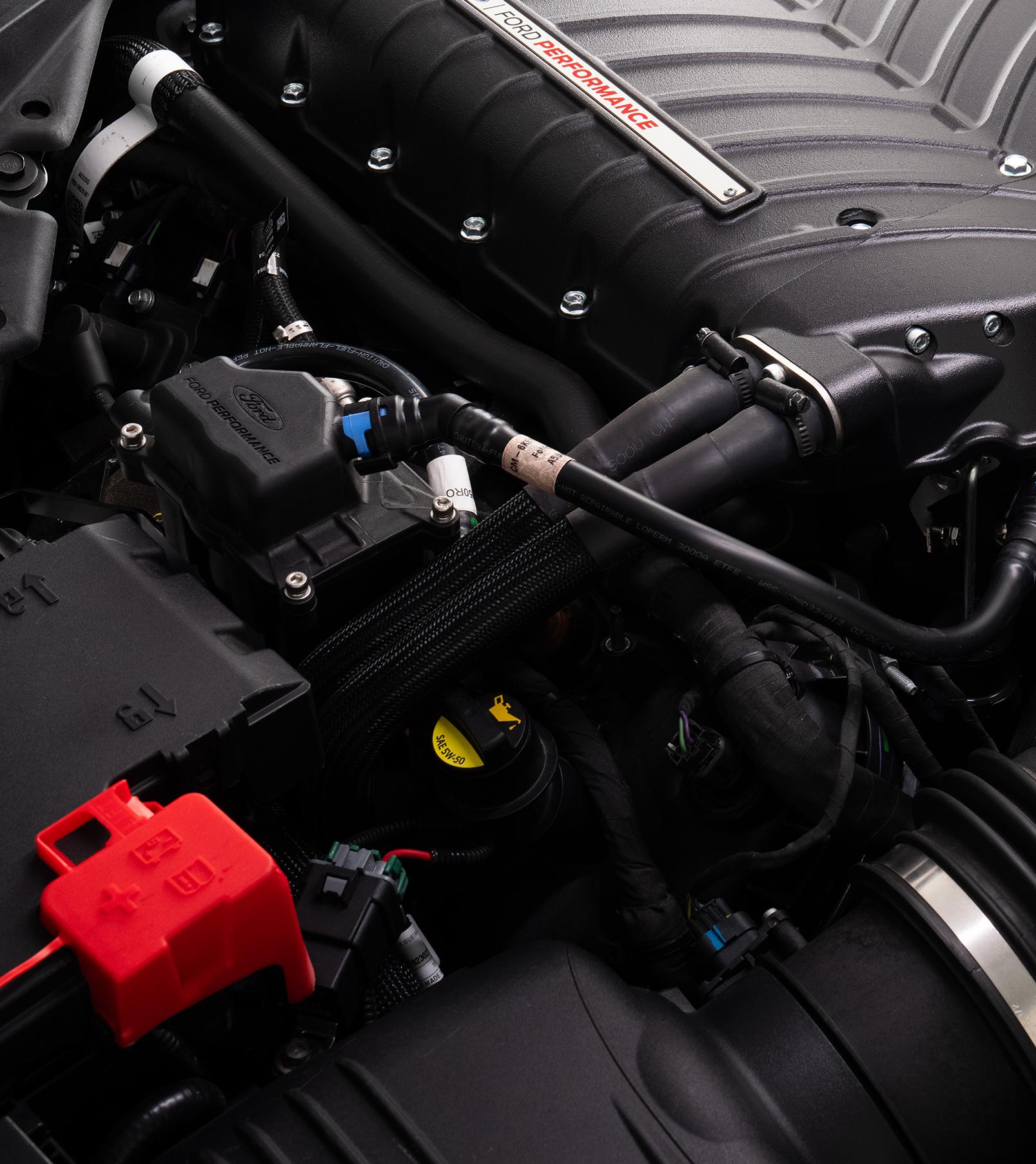 Engine bay detail showing the red Ford Performance air/oil separator kit