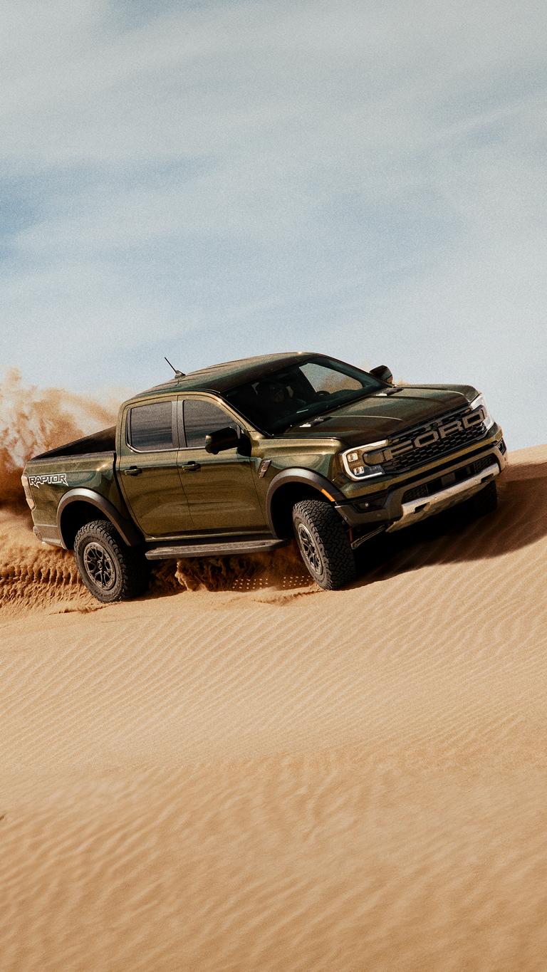 2026 Ford Ranger® Raptor® truck kicking up sand while being driven on a sand dune