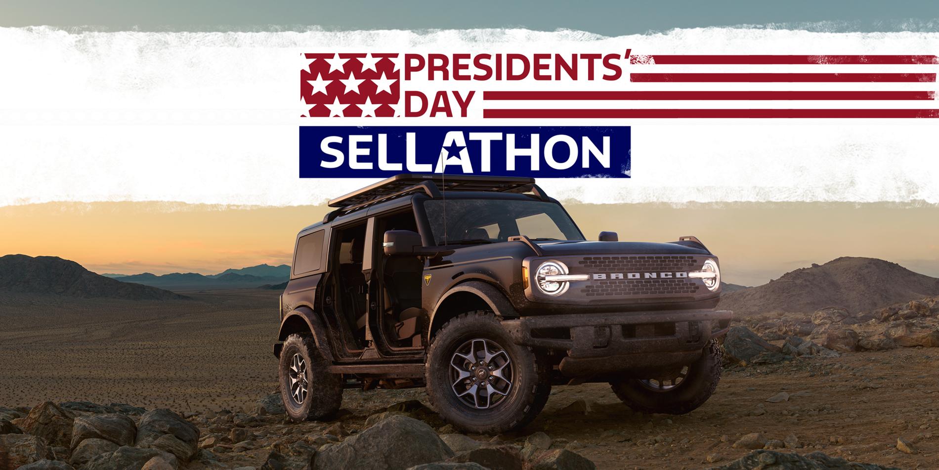 A gray 2025 Ford Bronco® SUV with doors off, sitting perched on the top of a desert ridge in twilight.