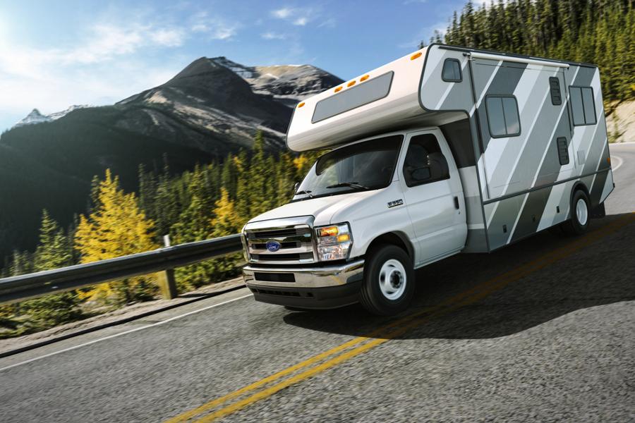 Fourgon tronqué Ford série E 2026 circulant sur une route montagneuse