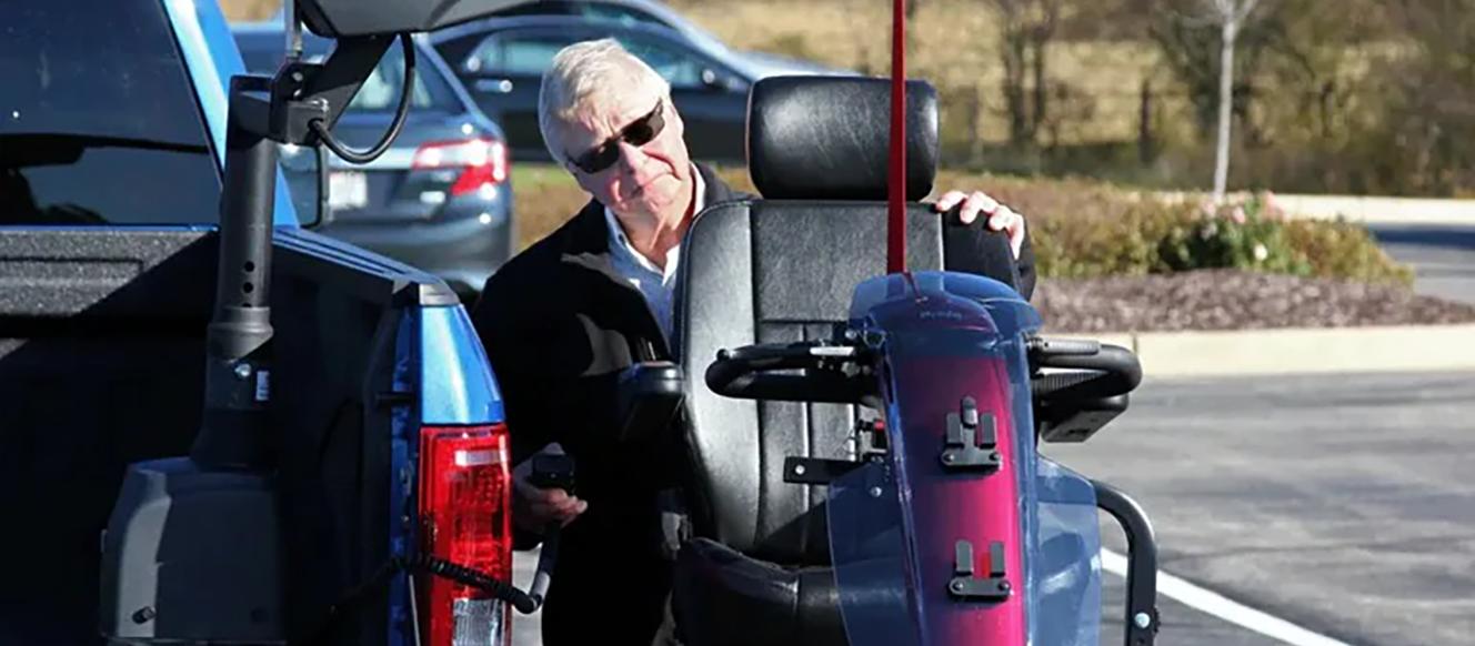 Person putting a wheelchair into a Ford vehicle