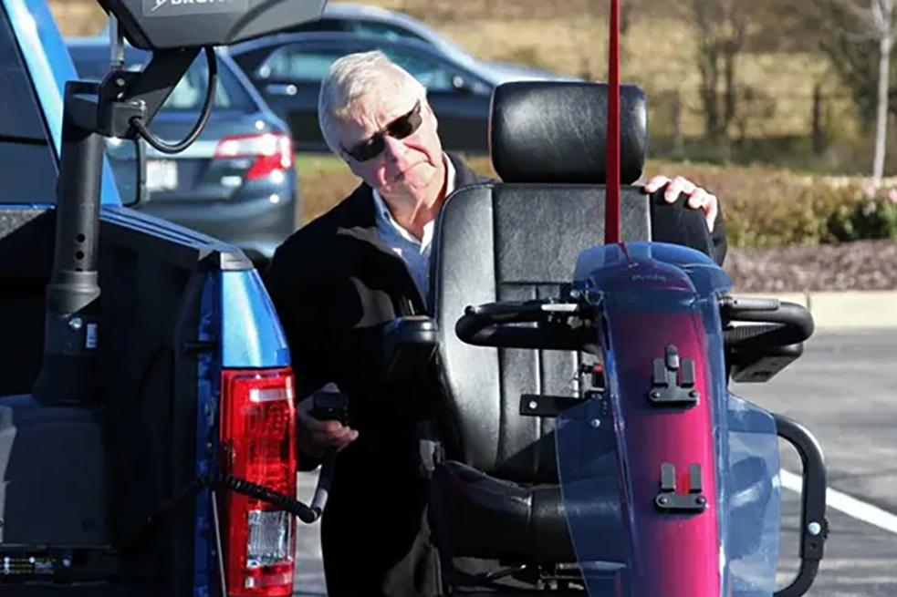 Person putting a wheelchair into a Ford vehicle