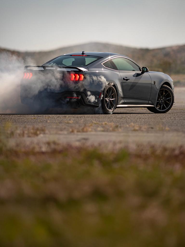 2026 Ford Mustang® Dark Horse® fastback in Vapor Blue Metallic with a driver performing burnouts on a closed course