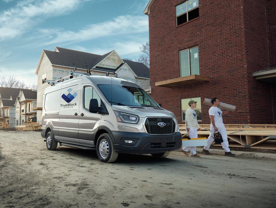 Two workers walking next to a 2026 Ford Transit® van parked in a development